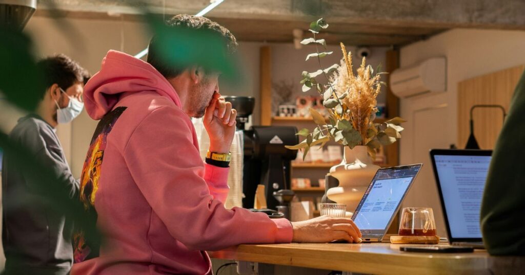 カフェで作業中のノートパソコン画面を周囲から見られる環境で覗き見防止フィルターを使うイメージ