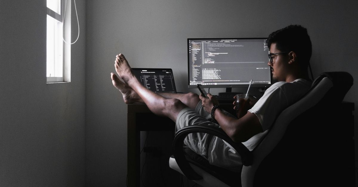 デスクでパソコン作業をする男性の足元